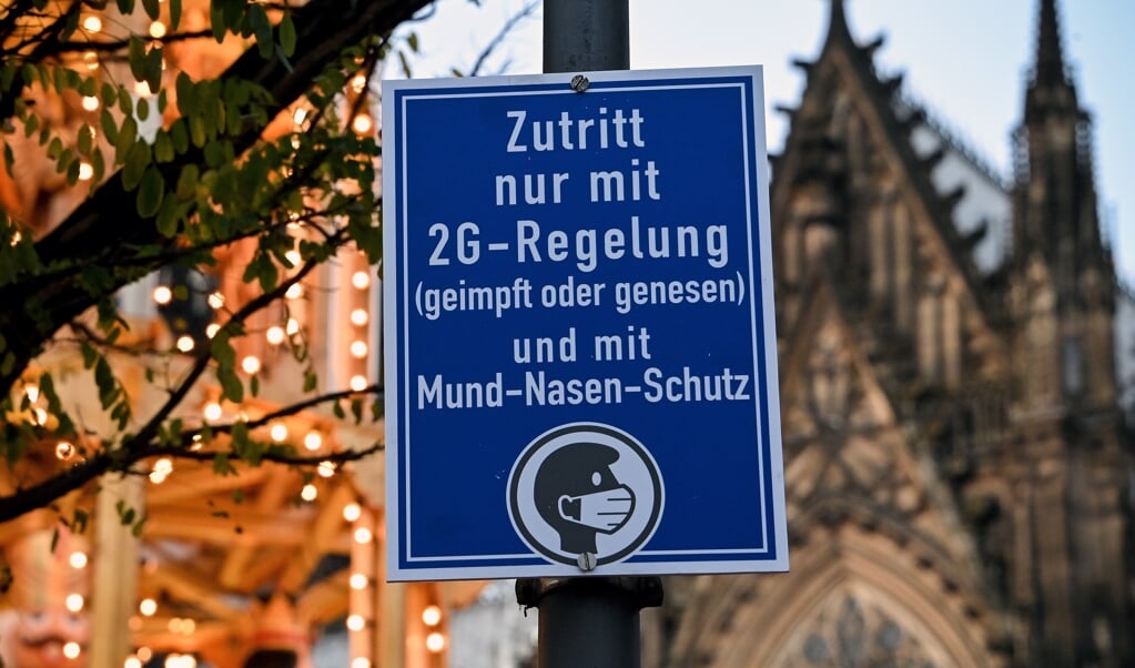 Op de kerstmarkt in de Duitse stad Keulen geldt 2G: alleen toegang als je gevaccineerd of genezen bent.  (beeld Epa/sascha Steinbach)