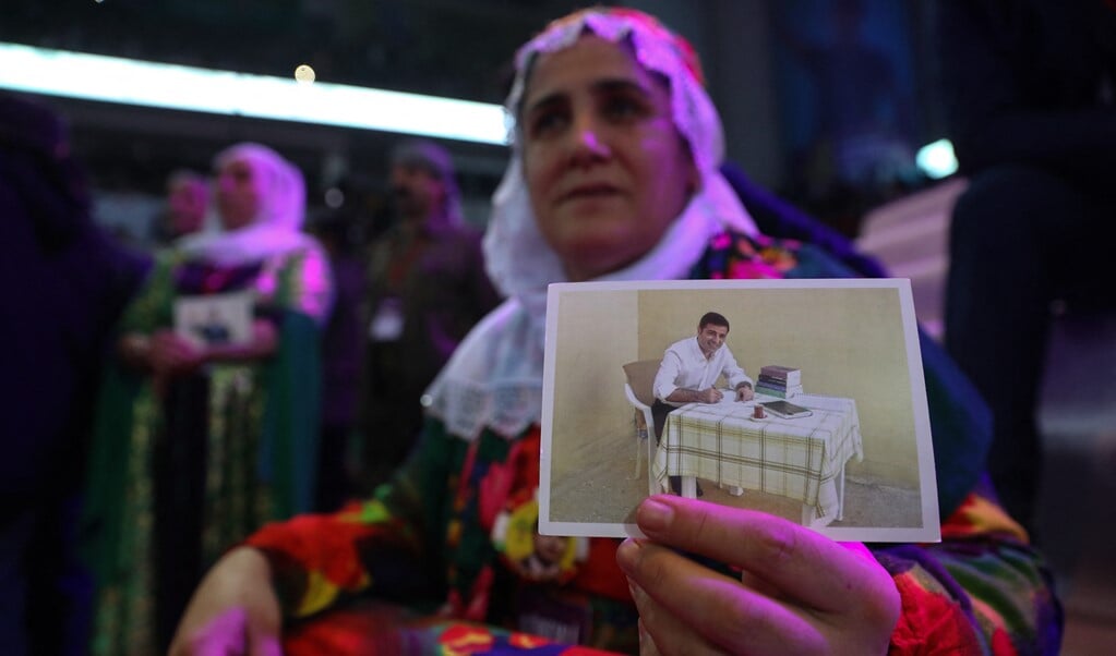 Een Koerdische vrouw toont een foto van politicus Selahattin Demirtas die in de gevangenis zit.  (beeld afp)