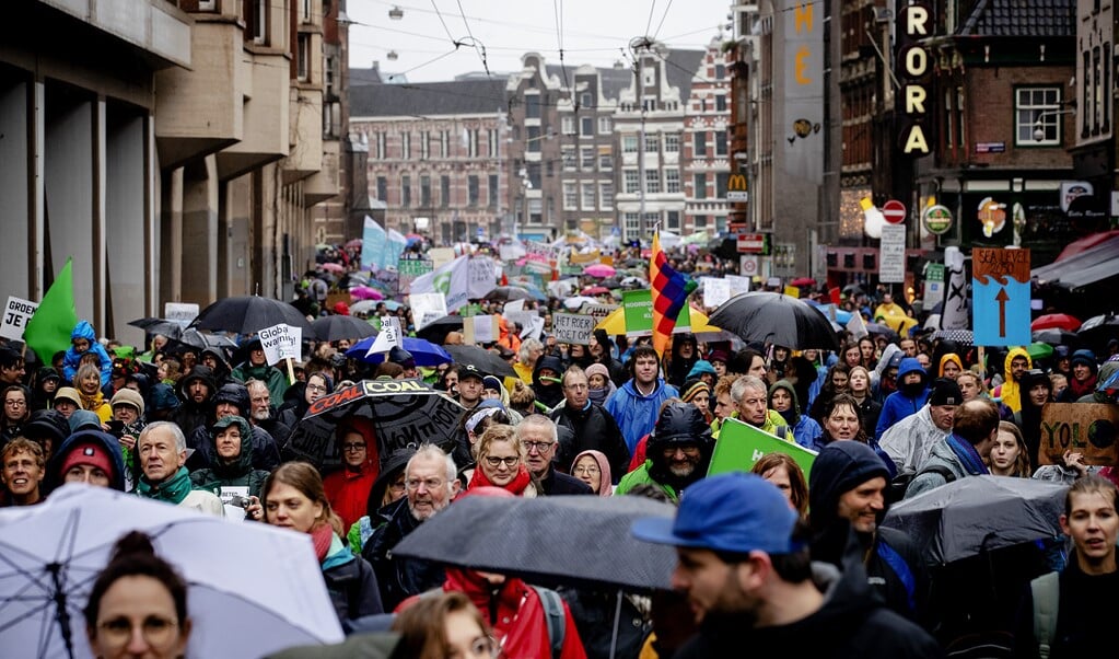 Deelnemers aan de kleddernatte klimaatmars van maart 2019 in Amsterdam. Ook aan die klimaatmars ging een viering vooraf.  (beeld anp / Robin van Lonkhuijsen)