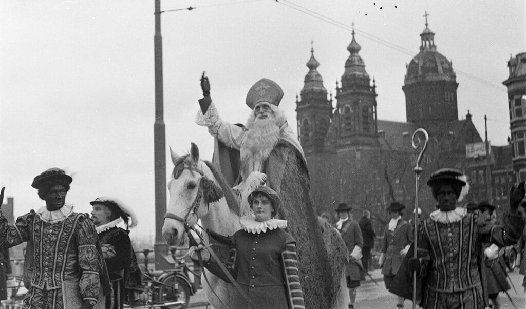 De intocht van Sinterklaas in Amsterdam in 1967 met op de achtergrond de Sint-Nicolaaskerk, die in 2012 door paus Benedictus XVI werd verheven tot basiliek.   (beeld anp)