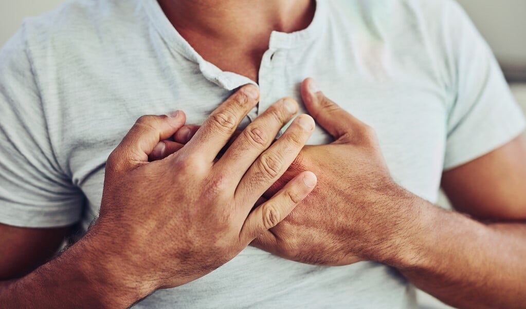 Shot of a unrecognisable young man holding his chest in discomfort with his hands due to pain in that area (beeld Yuri Arcurs peopleimages.com)