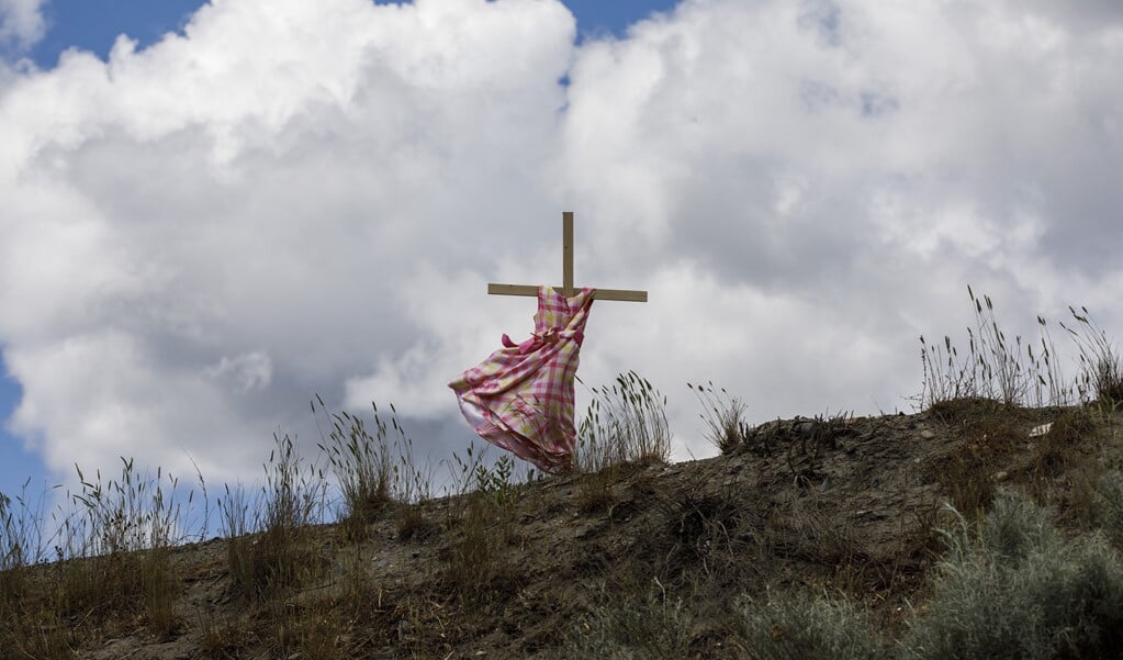 Een meisjesjurk bij het voormalige katholieke internaat in de Canadese plaats Kamloops waar eerder dit jaar de anonieme lichamen van 215 kinderen werden gevonden.  (beeld afp / Cole Burston )