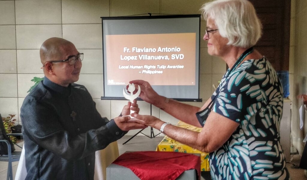 Ambassadeur Saskia de Lang in Manilla (Fillipijnen) overhandigt de 'lokale mensenrechtentulp' aan pater  Flaviano Villanueva SVD.  (beeld Vincent Go)