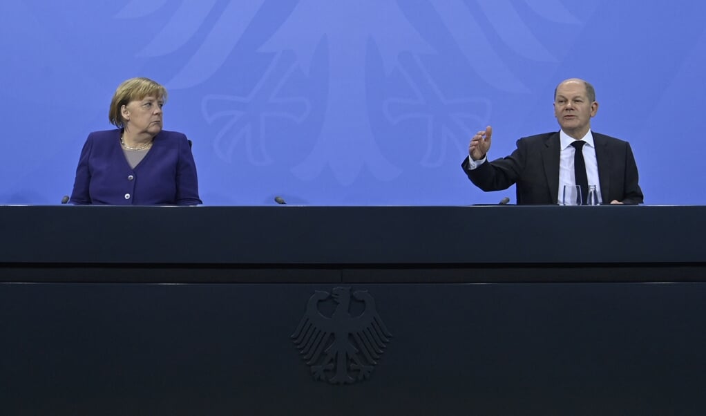 Angela Merkel en Olaf Scholz kondigden samen de vaccinatieplicht aan.  (beeld afp / John Macdougall)