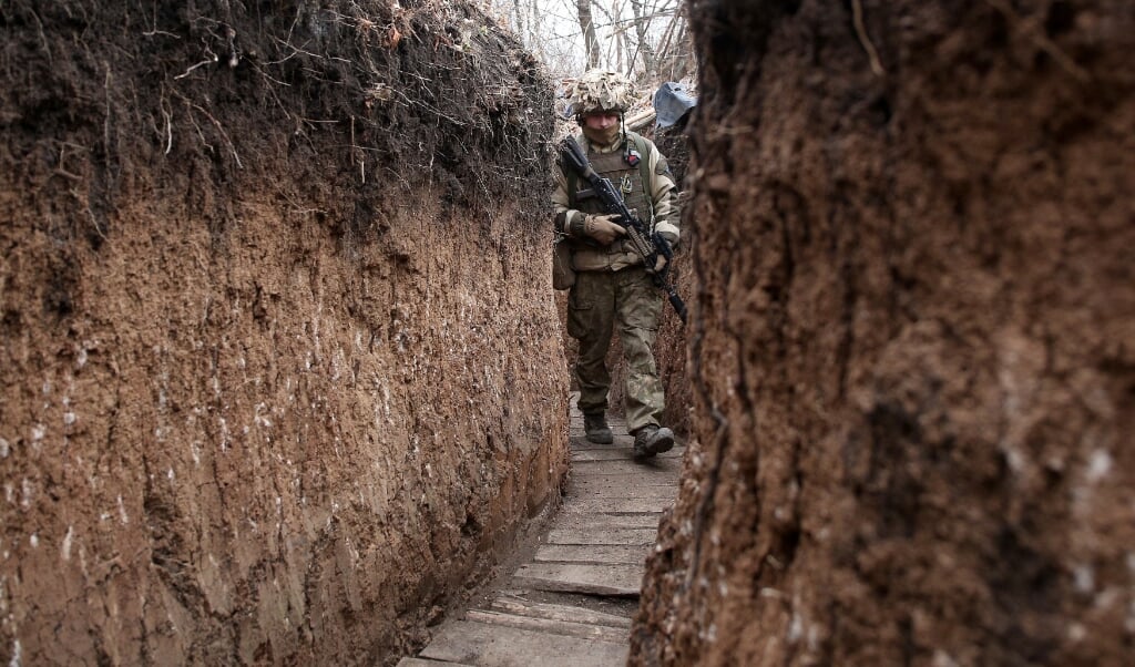 Een Oekraïense militair in een loopgraaf, dicht bij de Russische grens.   (beeld afp / Anatolii Stepanov)