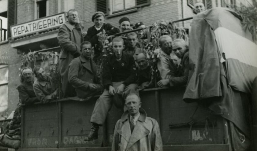 Pieter Kapenga, zittend uiterst rechts op de foto, keert vanuit Dachau terug in Nederland, eind mei 1945.