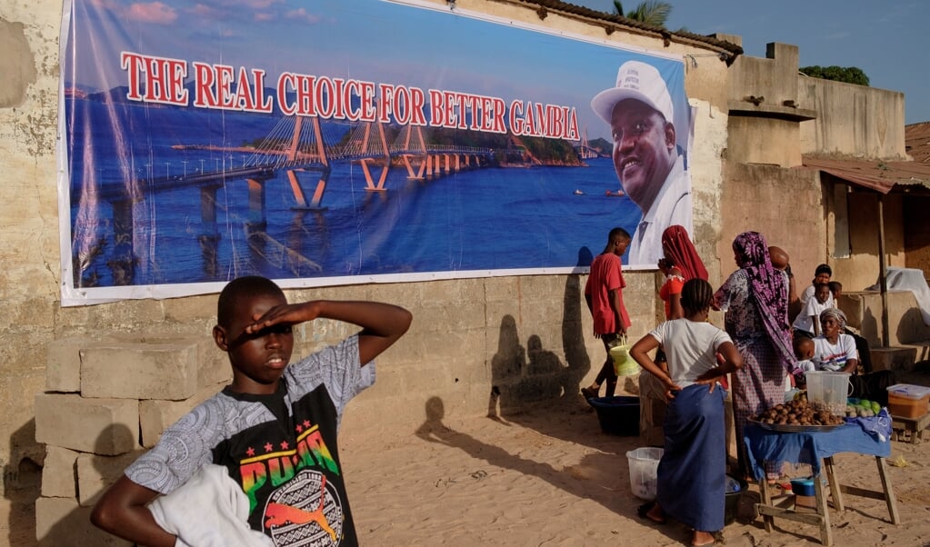 Een campagneposter in Banjul roept op om op National People’s Party van de huidige president Adama Barrow te stemmen.  (beeld afp / Guy Peterson)