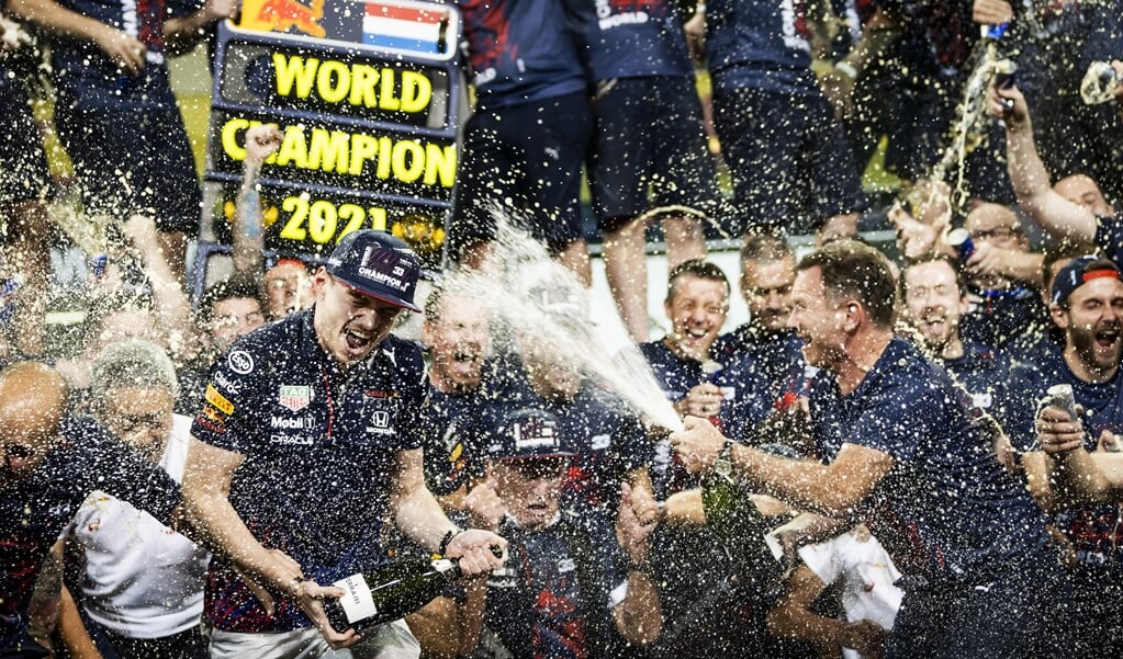Max Verstappen viert feest met zijn team na het winnen van het wereldkampioenschap Formule 1 na de Grand Prix van Abu Dhabi.  (beeld anp / Remko de Waal)
