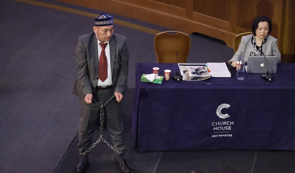 Tijdens het tribunaal liet getuige Omir Bekali zien hoe hij in een van de kampen werd geketend. (beeld afp / Tolga Akmen)