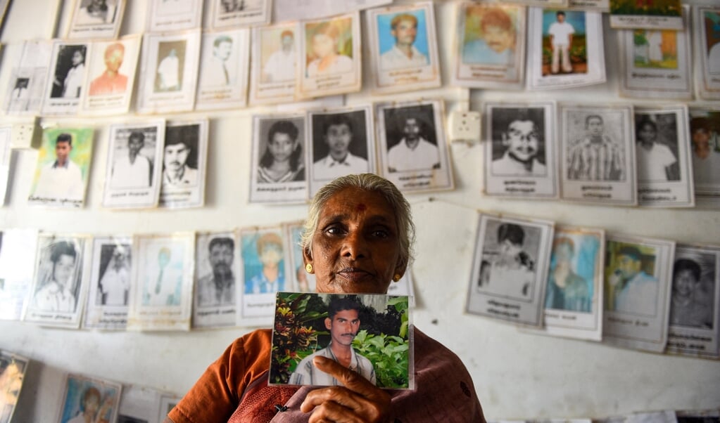 Een vrouw uit de Tamil-gemeenschap in Sri Lanka houdt een foto omhoog van een geliefde die is verdwenen tijdens de burgeroorlog. (beeld afp / Kodikara )