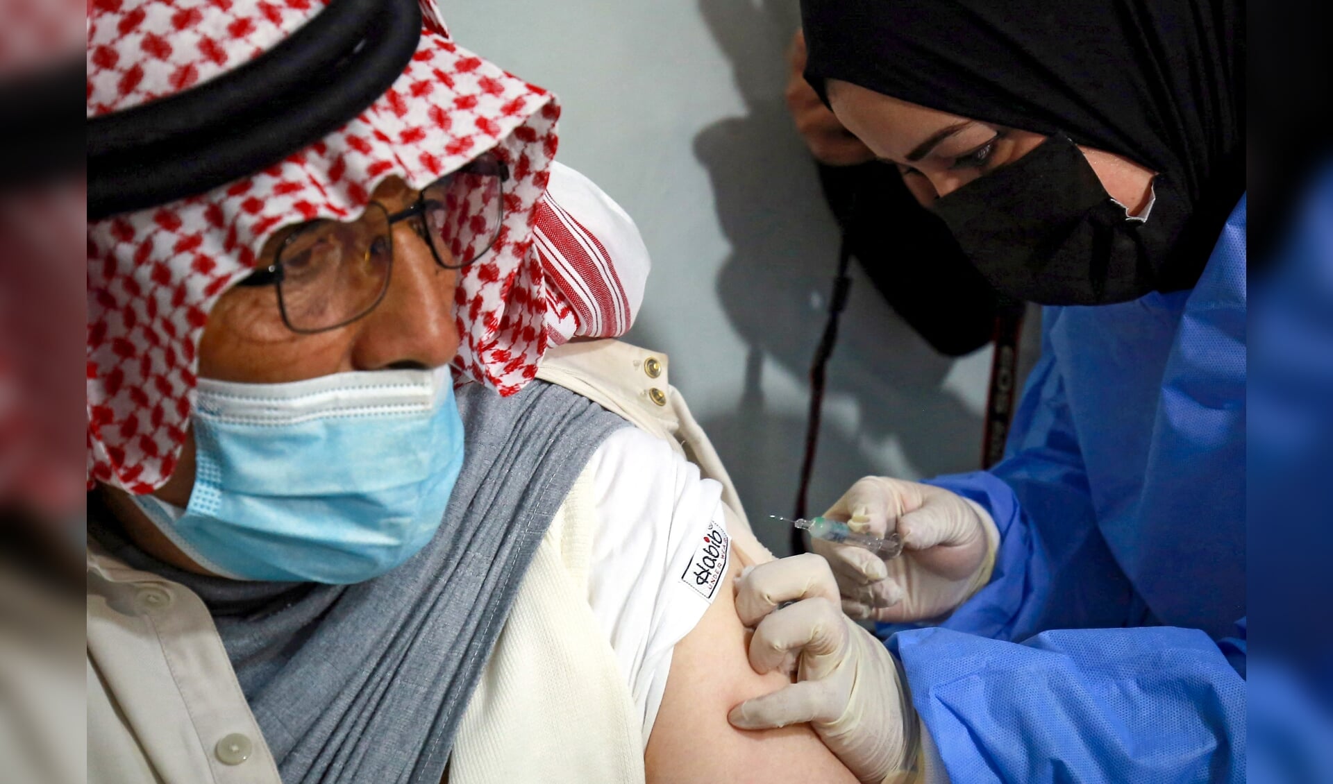 Een Syrische vluchteling krijgt een coronavaccin toegediend in het vluchtelingenkamp Zaatari.