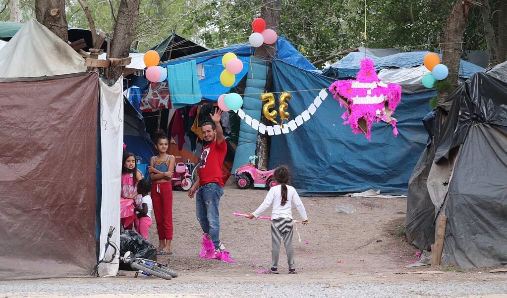 Migranten vieren een verjaardag in Kamp Matamoros in het noordoosten van Mexico. Op een halve vierkante kilometer wonen naar schatting zevenhonderd mensen in bouwsels van zeil en houten palen. (beeld epa / Abraham Pineda-Jacome)
