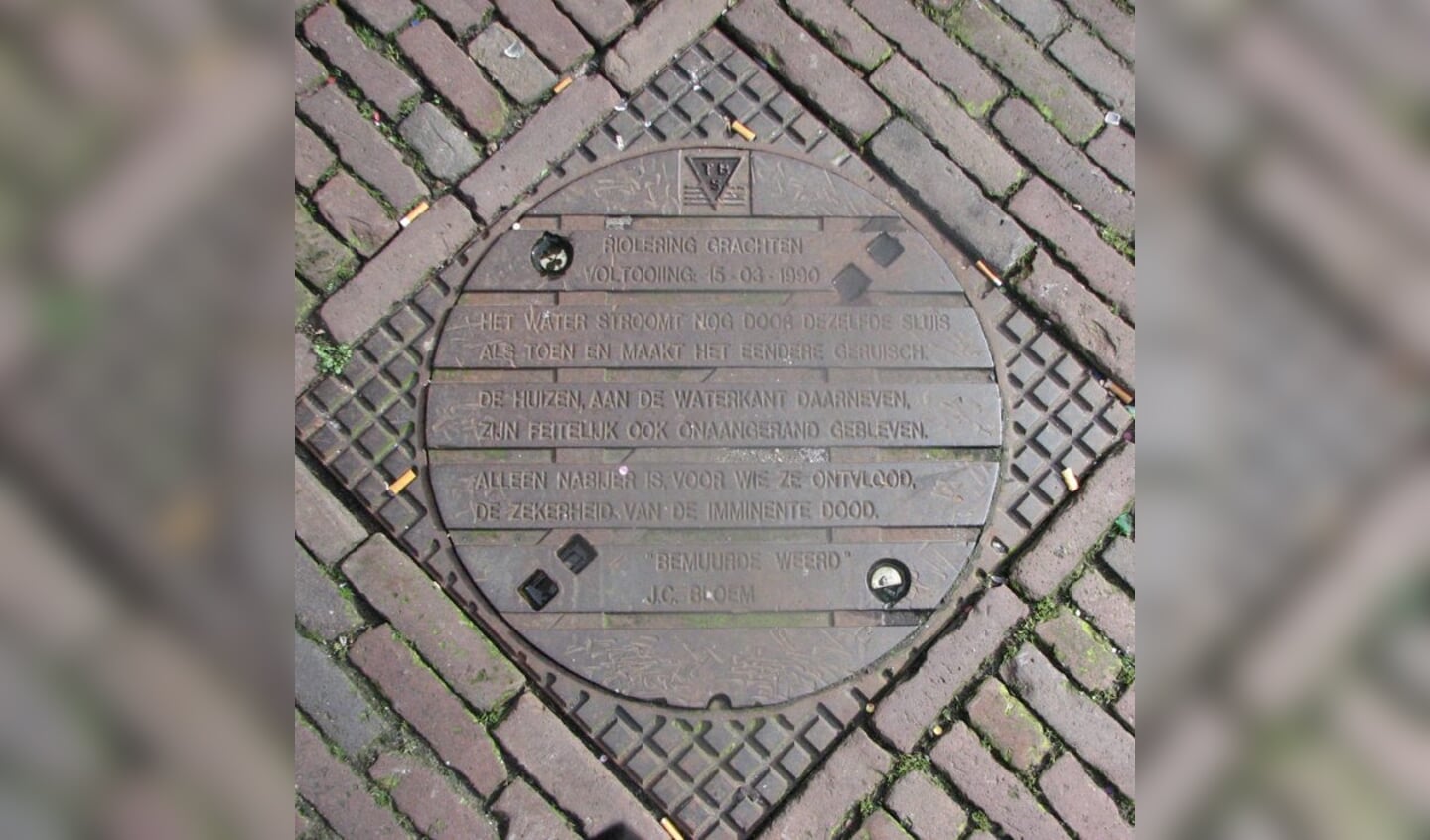 Een gedicht van J.C. Bloem op een putdeksel in Utrecht.