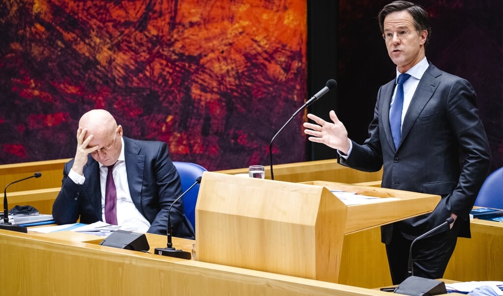 Ferdinand Grapperhaus, demissionair minister van Justitie en Veiligheid, en demissionair premier Mark Rutte tijdens het debat in de Tweede Kamer over de nieuwe spoedwet over de avondklok. (beeld anp / Sem van der Wal)
