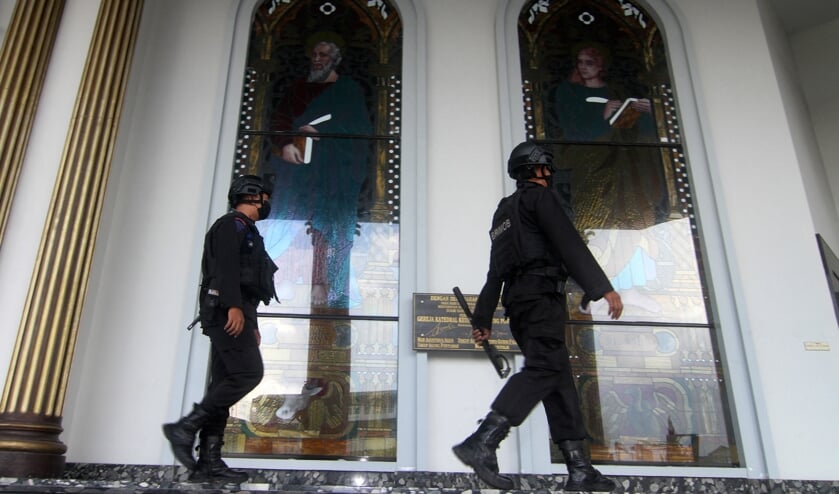 Politiemannen in de kathedraal van Pontianak op Borneo waar op Palmzondag een zelfmoordaanslag plaatsvond. (beeld afp / Andri Husen)