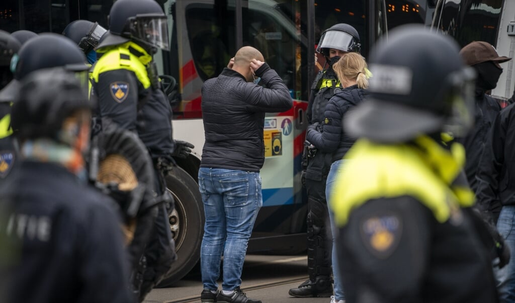 Actievoerders tegen de coronamaatregelen werden door de mobiele eenheid ingesloten en vervolgens in bussen weggevoerd. (beeld anp / Jeroen Jumelet)