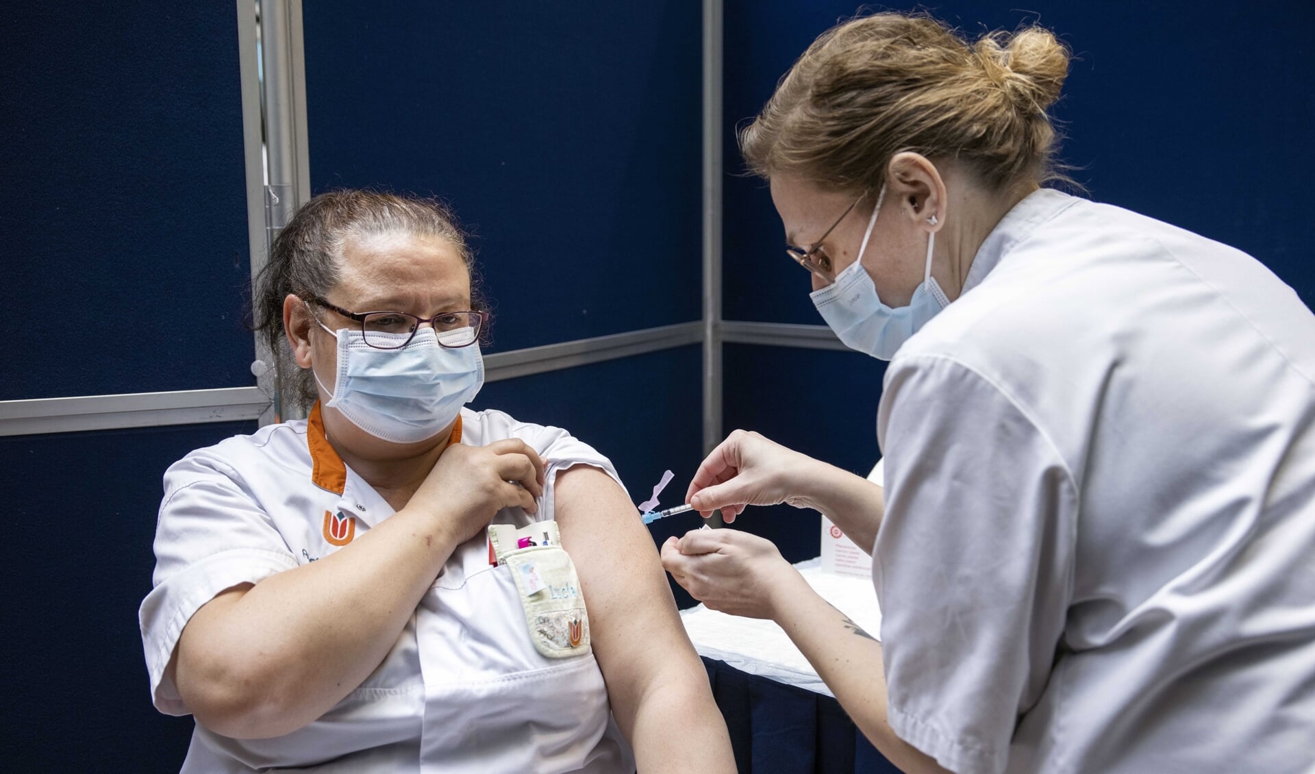 Een zorgmedewerker wordt met het Janssen-vaccin gevaccineerd tegen COVID-19. Het Janssen-vaccin zorgt, evenals het AstraZeneca-vaccin, mogelijk voor bijwerkingen. 