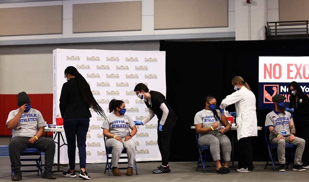 Studenten zitten in de rij in een priklocatie in New York. De vaccinatiecampagne verloopt in de VS erg voorspoedig. (beeld epa / Michael Santiago)