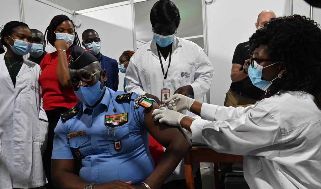 Een Ivoriaanse politieman krijgt het AstraZeneca-vaccin. Covax leverde als eerste vaccins aan Ivoorkust. In Afrika worden aan vijftig landen vaccins verstrekt door Covax. (beeld afp / Issouf Sanogo)