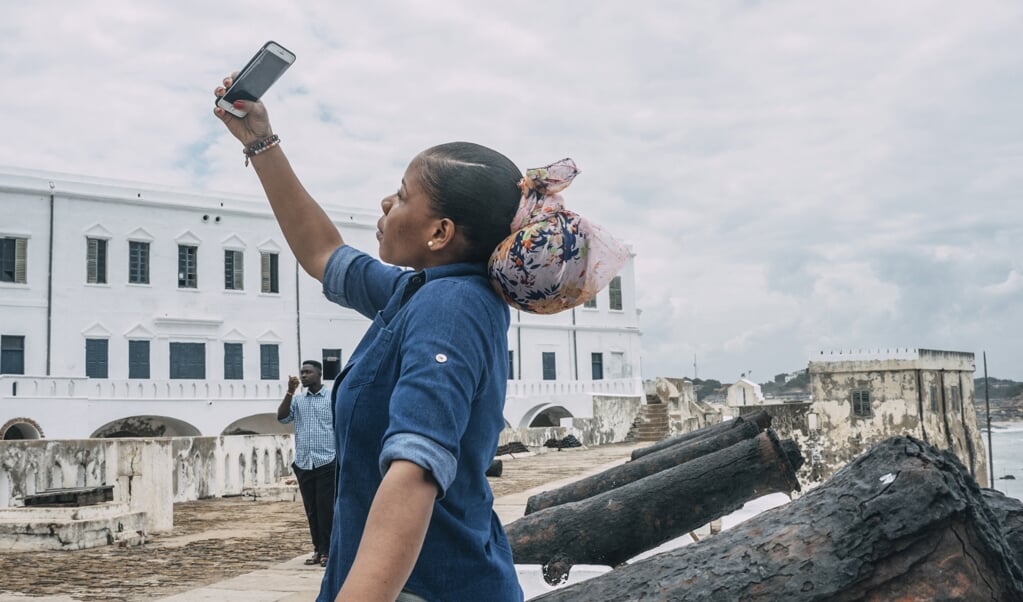 Een Amerikaanse toerist bezoekt het beruchte Cape Coast Castle in Ghana. Hier vertrok ruim vierhonderd jaar geleden het eerste slavenschip richting Virginia in de Verenigde Staten. (beeld Natalija Gormalova / AFP)