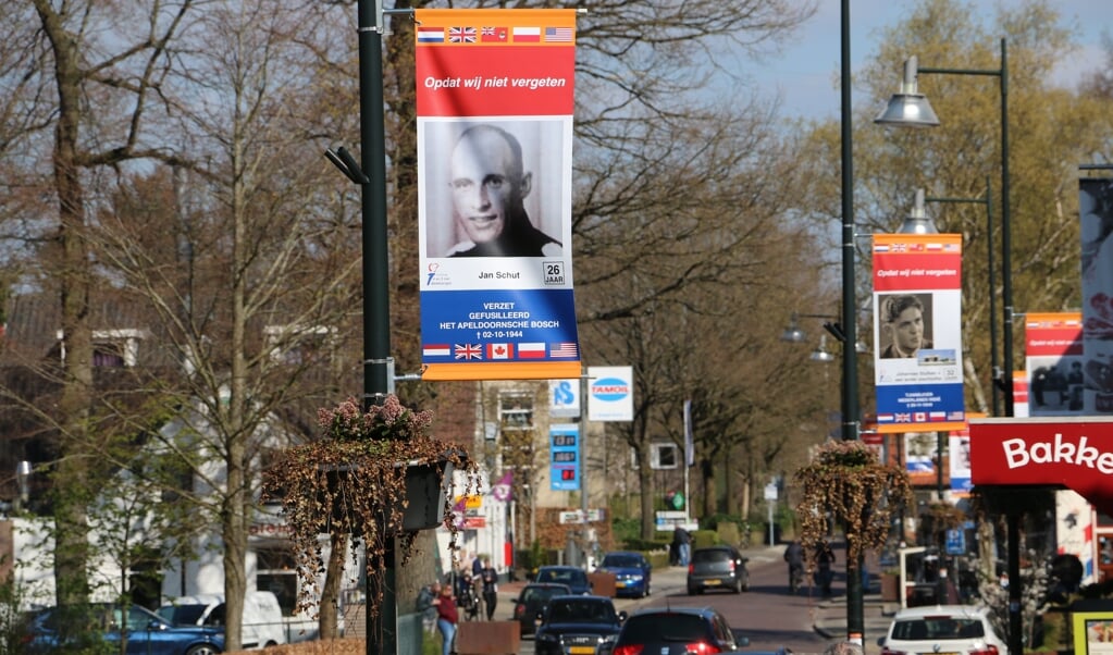 In het centrum van Beekbergen hangen 25 vlaggen van mensen die in de Tweede Wereldoorlog om het leven kwamen. (beeld Riekelt Pasterkamp)