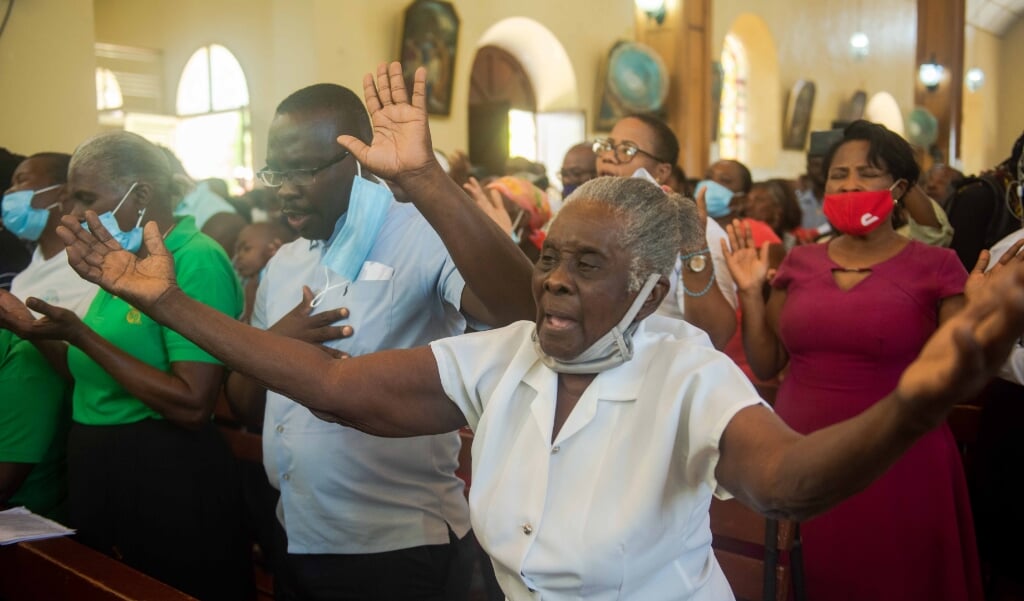 Katholieke gelovigen bidden in Port-au-Prince voor de vrijlating van de gegijzelden, waaronder meerdere priesters en vrouwelijke religieuzen. (beeld Epa / Jean Marc Herve Abelard)