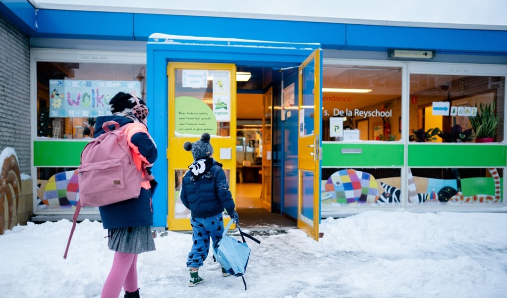 Kinderen komen in februari aan bij een basisschool in Den Haag, nadat het kabinet aankondigde dat de scholen weer open mogen.  (beeld anp / Bart Maat)