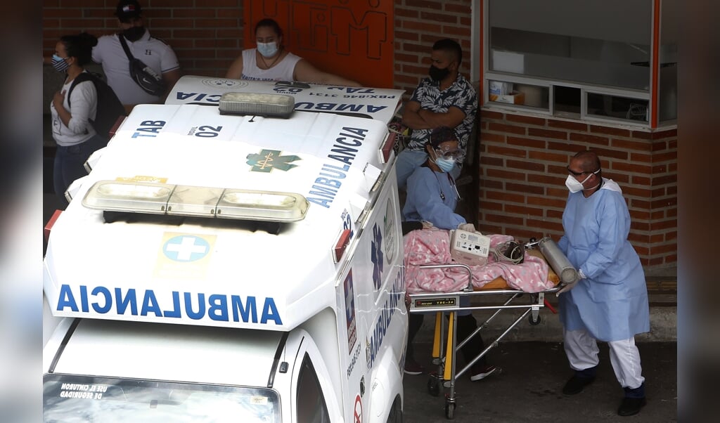 Een ambulance arriveert bij het ziekenhuis van de Colombiaanse hoofdstad Medellin. Het ziekenhuis kan het aantal coronapatiënten niet meer aan. (beeld Epa / Luis Eduardo Noriega)
