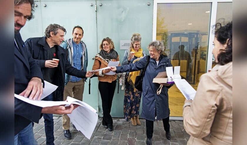 Bénédicte Ficq deelt bij het Paleis van Justitie exemplaren van de aangifte uit aan mede-ondertekenaars. (beeld anp / Olaf Kraak)