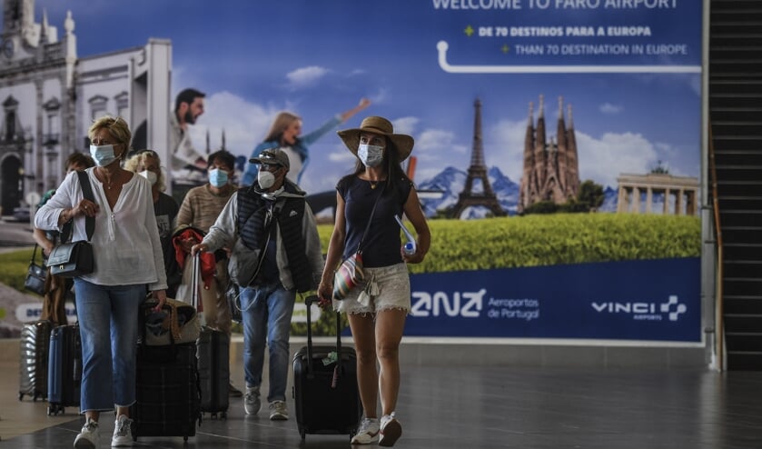 Vakantiegangers arriveren op het vliegveld van Faro in Portugal. (beeld afp / Patricia de Melo Moreira)
