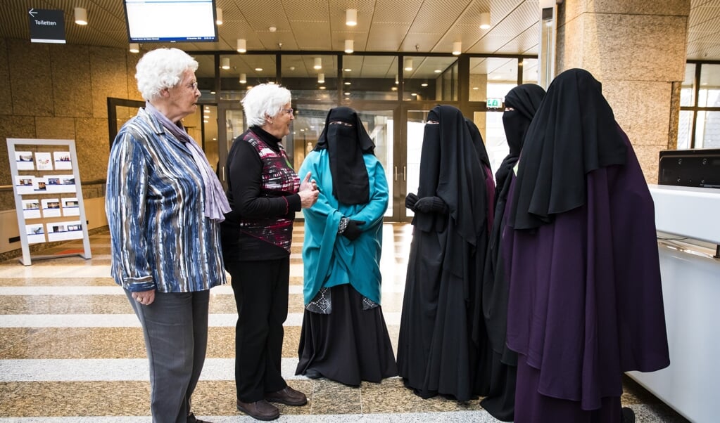 Bezoekers aan de Tweede Kamer raken, november 2016, met elkaar in gesprek op de dag van een debat over gezichtsbedekkende kleding. 'In de ontmoeting met de ander (...) leer je hoe je elkaar met respect bejegent.' (beeld anp / Bart Maat)