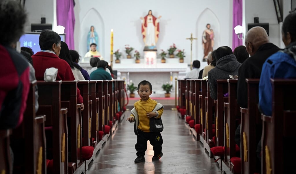 In een katholieke kerk in een dorp vlakbij de Chinese hoofdstad Beijing vierden gelovigen op 3 april het Paasfeest. (beeld afp / Jade Gao )