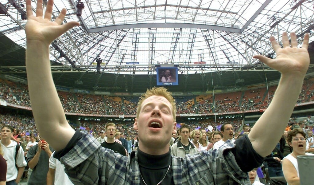 Archiefbeeld van een jonge liedtraditie: aanbiddingsmuziek klinkt tijdens de 27e EO-Jongerendag, juni 2001, in het Amsterdamse voetbalstadion dat toen nog de Amsterdam ArenA heette. (beeld anp / Marcel Antonisse)
