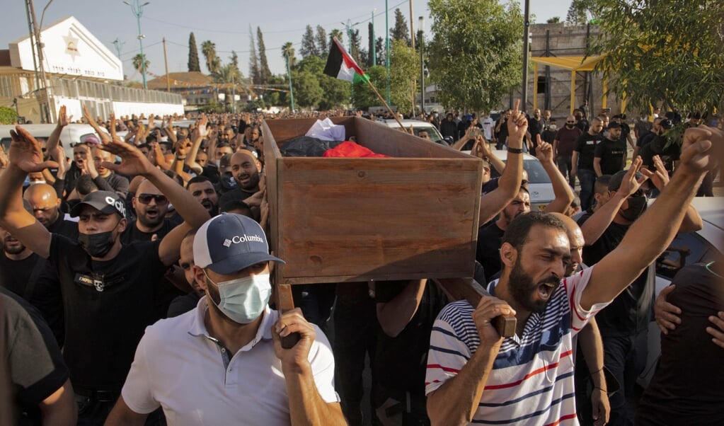 Israëlische Arabieren op 11 mei 2021 tijdens de begrafenis van een bij de een betoging omgekomen man in de stad Lod. (beeld afp)