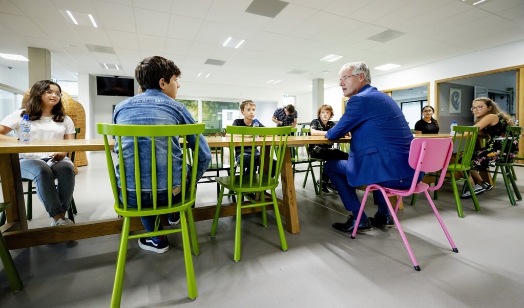 Minister Arie Slob (Basis- en Voortgezet Onderwijs en Media) praat met leerlingen tijdens de start van het schooljaar. (beeld anp / Robin van Lonkhuijsen)