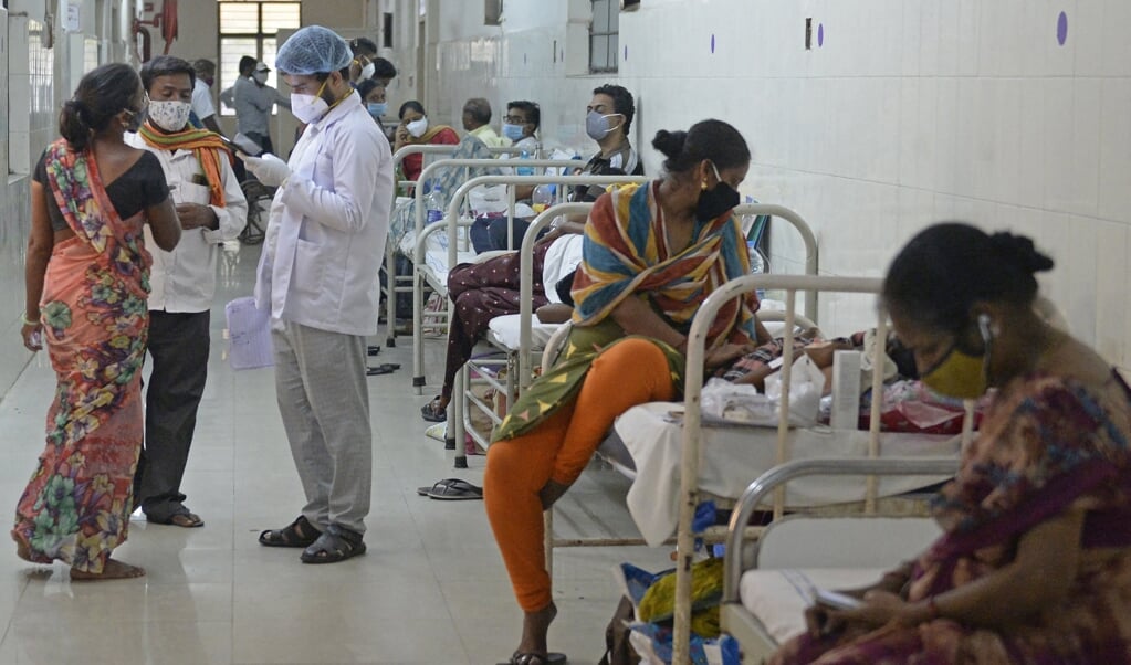 Een dokter spreekt met familieleden van een patiënt die herstellende is van corona. In India liggen de ziekenhuizen overvol met mensen die covid of de dodelijke ‘zwarte schimmel’-ziekte onder de leden hebben. (beeld afp / Noah Seelam)