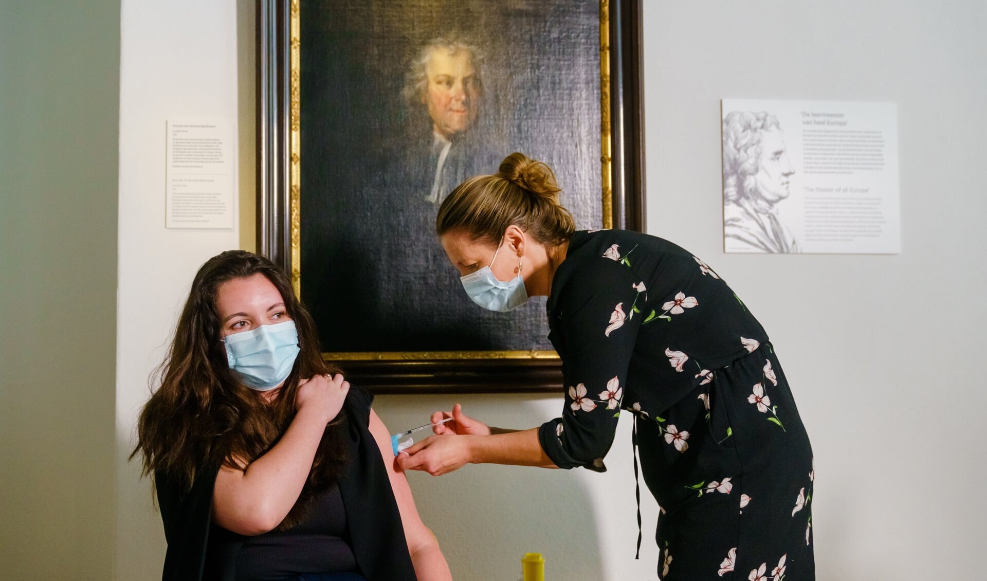 Een huisarts dient in Rijksmuseum Boerhave een vaccin toe bij een medewerker van de GGZ.