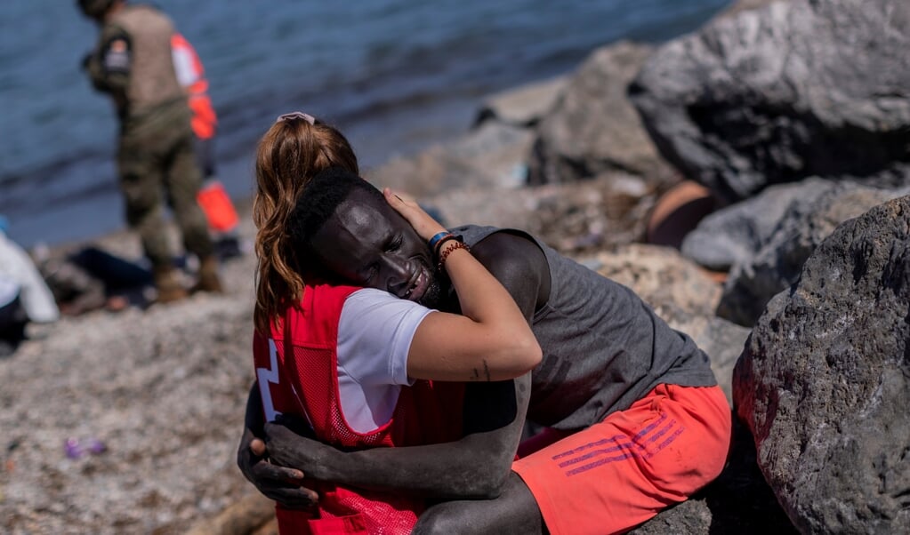Rode Kruismedewerker Luna Reyes helpt een Senegalese migrant in het Spaanse deel van Marokko, Ceuta. Ze wordt geprezen om haar medemenselijkheid, maar ontving ook zo veel racistische en seksistische opmerkingen dat ze besloten heeft haar accounts op sociale media op te heffen. (beeld Hollandse Hoogte / ap)