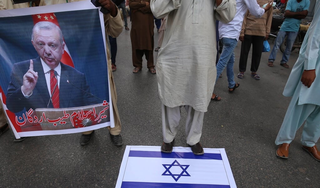 Demonstranten in Pakistan houden een portret van de Turkse president Erdogan vast, tijdens een protest tegen Israël. Turkije werpt zich op als verdediger van Palestijnse belangen in het oplaaiende conflict met Israël. (beeld epa / Rehan Khan)