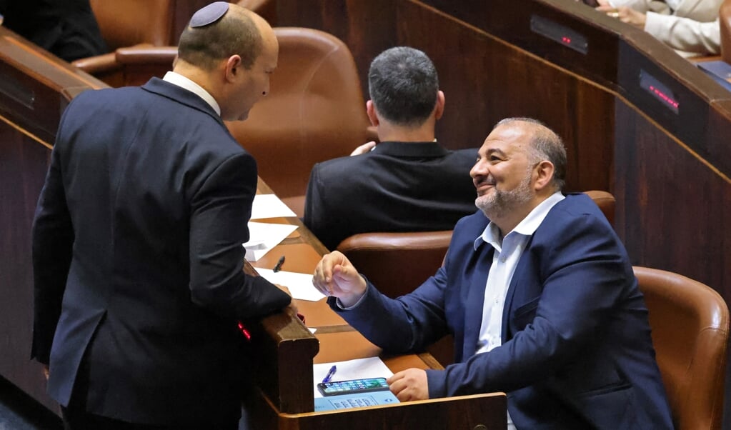 De nieuwe Israëlische premier Naftali Bennett (links) in gesprek met Mansour Abbas, leider van de Israëlisch-Arabische partij Ra’am (die ook deelneemt aan de coalitie). (beeld afp / Emmanuel Dunand)