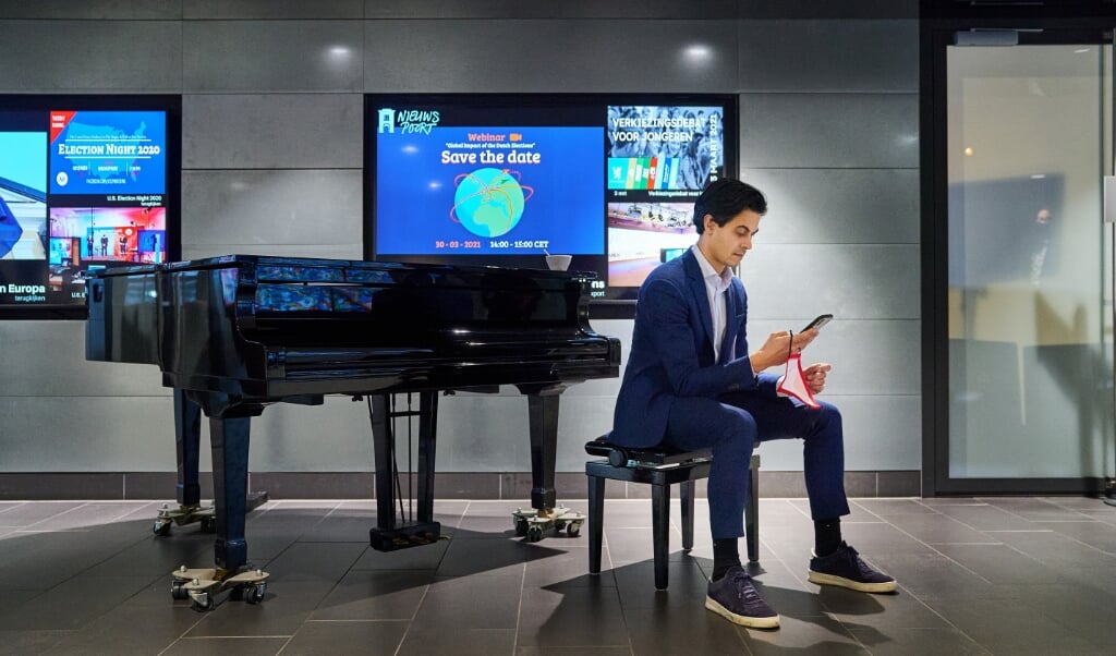 D66-fractievoorzitter Rob Jetten leest het laatste nieuws door op zijn telefoon over de analyse en doorrekening van de verkiezingsprogramma's 2021-2025 door het Centraal Planbureau (CPB) en het Planbureau voor de Leefomgeving (PBL), 1 maart. (beeld anp / Phil Nijhuis)