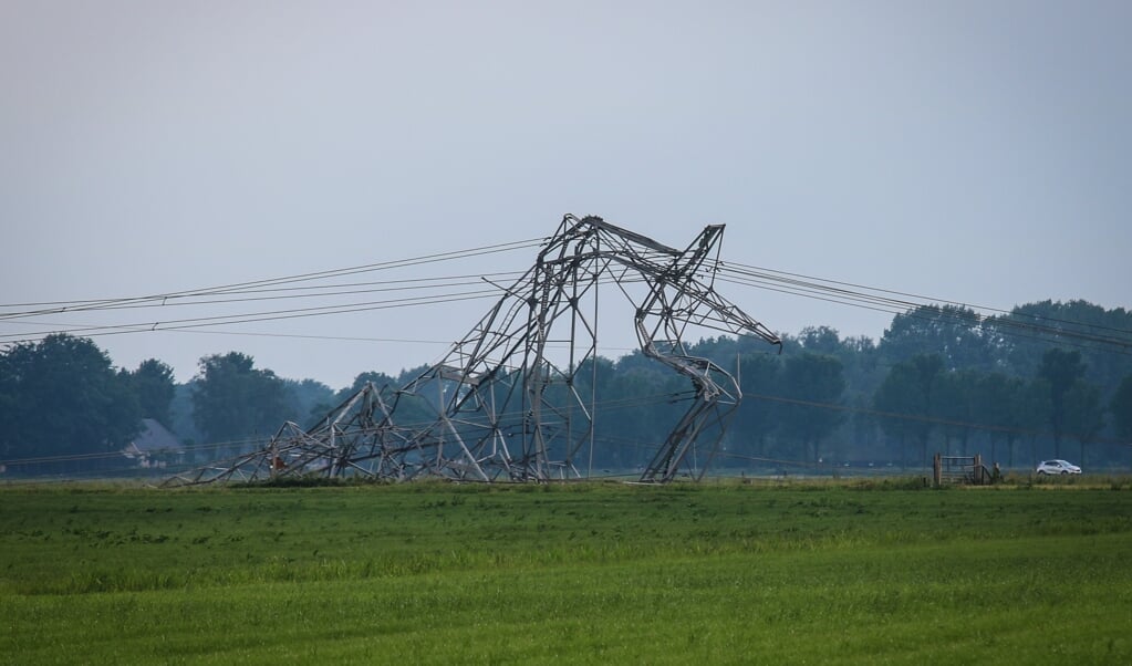 Een van de vier omgewaaide elektriciteitsmasten in het Gelderse Oosterwolde. Volgens de gemeente Oldebroek is de schade groot. (beeld anp)