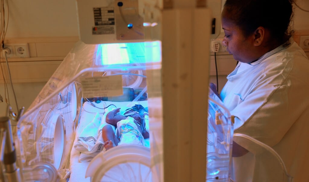 Een verpleegkundige verleent zorg aan een baby in een couveuse in het Diakonessenhuis in Paramaribo. (anp / Jaco Klamer)
