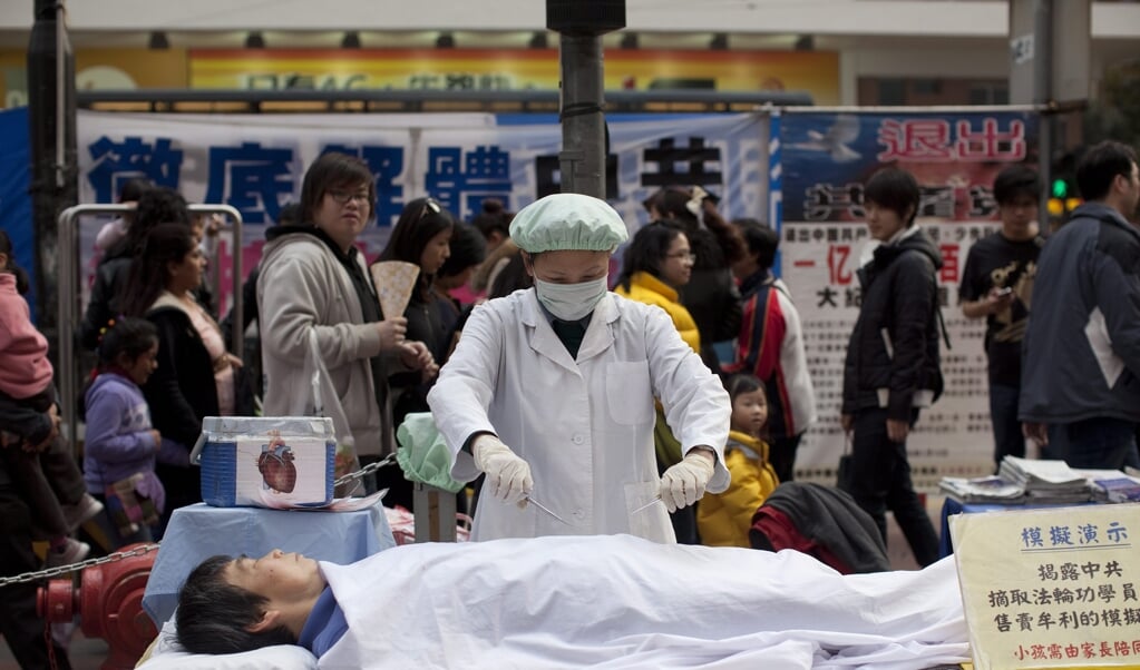 Leden van de Falun Gong-beweging protesteren verkleed tegen gedwongen 'orgaanoogst' op het station van Hongkong in 2012. (beeld epa / Jerome Favre)