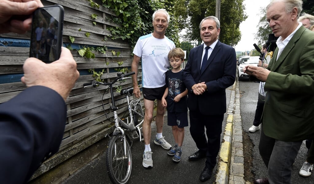 Oud-minister Xavier Bertrand ontmoet op weg naar het stembureau dorpelingen in Saint-Quentin. (beeld afp / Francois lo Presti)