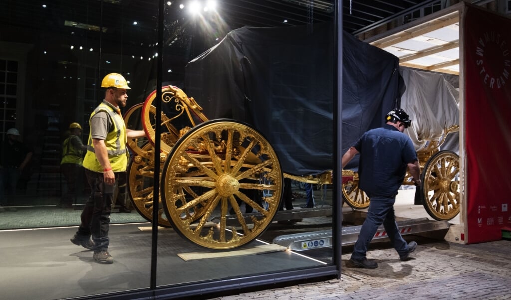 2021-06-10 03:01:35 AMSTERDAM - De Gouden Koets is met behulp van een hijskraan in het Amsterdam Museum geplaatst. De gerestaureerde Gouden Koets, die ruim 2.800 kilo weegt, is hier als middelpunt van een gelijknamige tentoonstelling acht maanden lang van dichtbij te zien voor publiek. ANP OLAF KRAAK (beeld anp / Olaf Kraak)