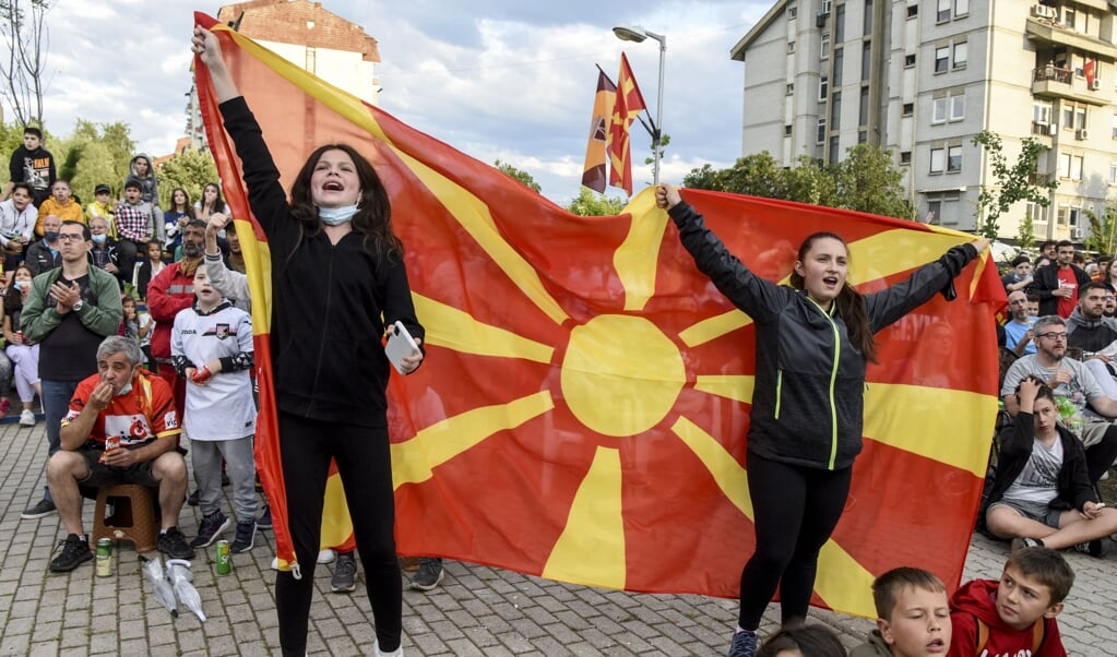 Supporters met de vlag van Noord-Macedonië tijdens het duel met Oostenrijk. (beeld afp / Robert Atanasovski)