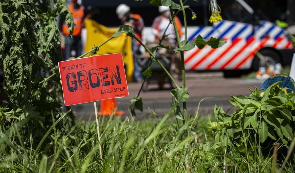 Klimaatactivisten zetten buiten het hoofdkantoor van Shell, tijdens een aandeelhoudersvergadering mei, dit jaar, de oliemaatschappij onder druk sneller stappen te zetten tot verduurzaming. Goed klimaatbeleid voer je samen met bedrijven, niet tegenover. (beeld anp / Carmen Hofstede)