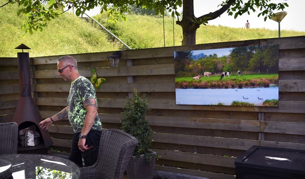 De achtertuin van een bewoner in Heesselt, met op de achtergrond de Waaldijk. (beeld Marcel van den Bergh)