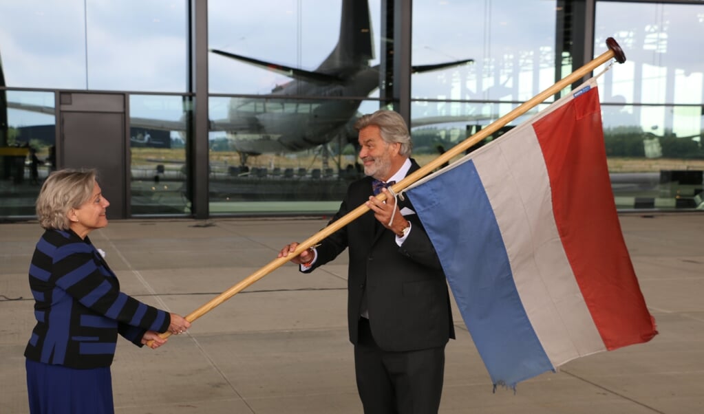Minister van Defensie Ank Bijleveld draagt een van de missievlaggen over aan directeur Paul van Vlijmen van het Nationaal Militair Museum. (beeld Riekelt Pasterkamp)